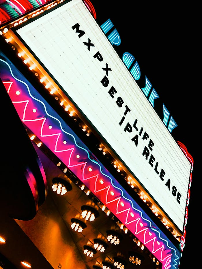 Vibrant neon-lit theater marquee showcasing MXPX Best Life IPA Release at night.